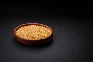 Ptitim wheat porridge grains on a dark concrete background photo