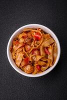 Delicious asian udon dish with vegetables, mushrooms, salt and spices photo