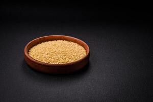 Raw risoni pasta made from durum wheat on a dark concrete background photo