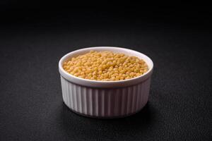 Ptitim wheat porridge grains on a dark concrete background photo