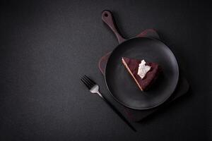 Piece of delicious sweet chocolate cake with sponge cake and cream photo