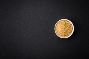 Raw risoni pasta made from durum wheat on a dark concrete background photo