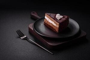 Piece of delicious sweet chocolate cake with sponge cake and cream photo