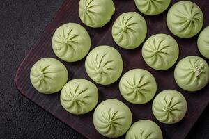 Raw khinkali or green dumplings with salt, spices and herbs photo