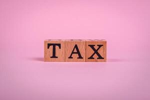 The inscription Tax made of wooden cubes on a plain background photo