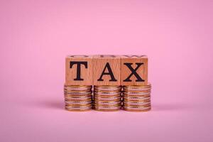 The inscription Tax made of wooden cubes on a plain background photo