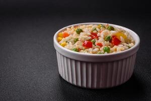 Delicious white boiled rice with vegetables, sweet peppers, carrots, peas photo