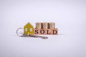 The inscription Sold made of wooden cubes on a plain background photo