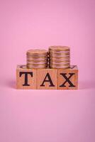 The inscription Tax made of wooden cubes on a plain background photo