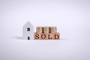 The inscription Sold made of wooden cubes on a plain background photo