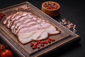 Delicious fresh pancetta or bacon with salt and spices cut into thin slices photo