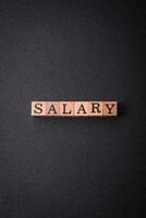 The inscription Salary made of wooden cubes on a plain background photo