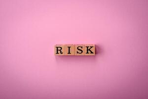 The inscription Risk made of wooden cubes on a plain background photo