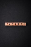 The inscription Penalty made up of wooden cubes on a plain background photo