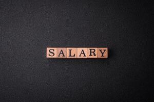 The inscription Salary made of wooden cubes on a plain background photo