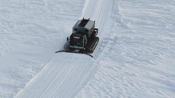 Snowcat tirelessly shapes ski slopes at snowy forests aerial view Snowcat guardian smooth skiing surfaces. Snowcat harnessing technology craft perfect winter trails In each sweep redefines snowy. video