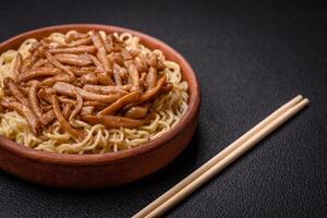 Delicious Asian cuisine dish with rice noodles, peppers, mushrooms and spices photo