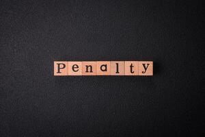 The inscription Penalty made up of wooden cubes on a plain background photo