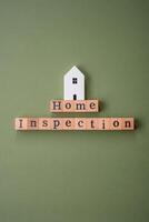 The inscription Home inspection made of wooden cubes on a plain background photo