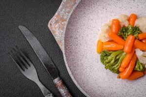delicioso Fresco vegetales brócoli, coliflor, zanahorias al vapor con sal y especias foto