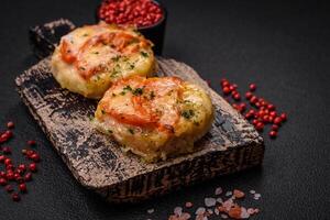 Delicious baked fish fillet with cheese, tomatoes, salt, spices and herbs photo