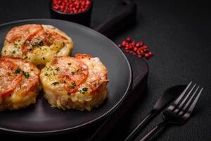 Delicious baked fish fillet with cheese, tomatoes, salt, spices and herbs photo