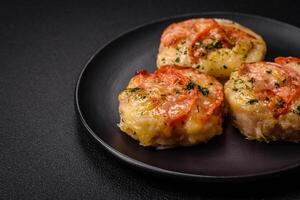 Delicious baked fish fillet with cheese, tomatoes, salt, spices and herbs photo