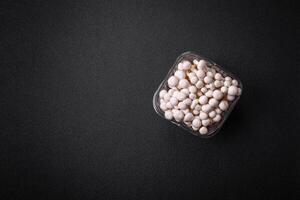 Small white edible beech mushrooms with salt and spices on a plain background photo