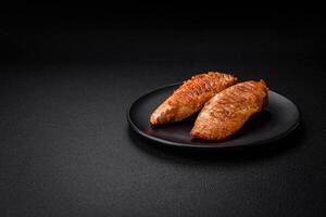 Delicious fresh grilled chicken fillet with spices and herbs on a dark concrete background photo