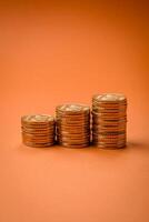 Round metal yellow coins folded in the form of columns on a plain colored background photo