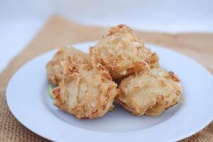 Bakwan sayur or vegetable fritter, Indonesian snack made from flour, cabbage, carrots and bean sprouts, served with chili photo