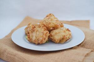 Bakwan sayur or vegetable fritter, Indonesian snack made from flour, cabbage, carrots and bean sprouts, served with chili photo