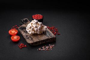 Small white edible beech mushrooms with salt and spices on a plain background photo