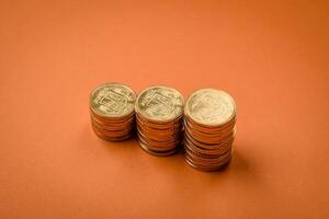 Round metal yellow coins folded in the form of columns on a plain colored background photo