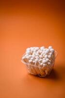 Small white edible beech mushrooms with salt and spices on a plain background photo