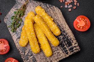 Delicious crispy cheese sticks with mozzarella, salt and spices, breaded and fried in oil photo