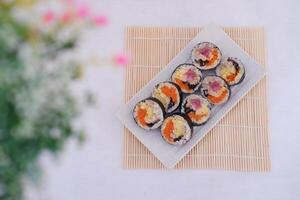 Sushi rollos en un plato en un blanco antecedentes. japonés comida foto