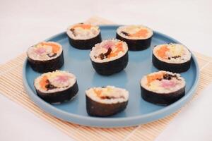 Sushi rollos en un plato en un blanco antecedentes. japonés comida foto