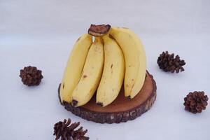 Bunch of bananas on a wooden stand on a white background. photo