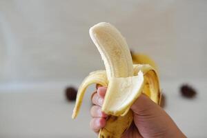 Banana on a wooden plate in the hands of a girl. Selective focus. photo