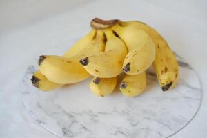 Bunch of bananas on a white marble table. Selective focus. photo