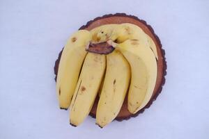 Bunch of bananas on a wooden stand on a white background. photo
