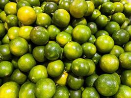 Top view of fresh green lemons as a background. photo