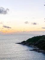 The horizon stretches endlessly, framing a paradise bay where waves crash against the shoreline, creating a dynamic and captivating seaside scenery. photo