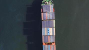 Top down view from drone of a passing container ship at sea with oil stains video