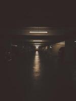 The dimly lit empty parking garage exudes a grunge atmosphere with its worn-out asphalt. photo