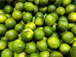 Top view of fresh green lemons as a background. photo