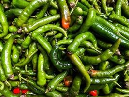 Backdrop of green chilli peppers texture background. Close up view with copy space for design photo