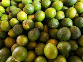 Top view of fresh green lemons as a background. photo