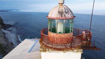 Aerial view of the old Balyuzek lighthouse on the rocky coast of the sea video